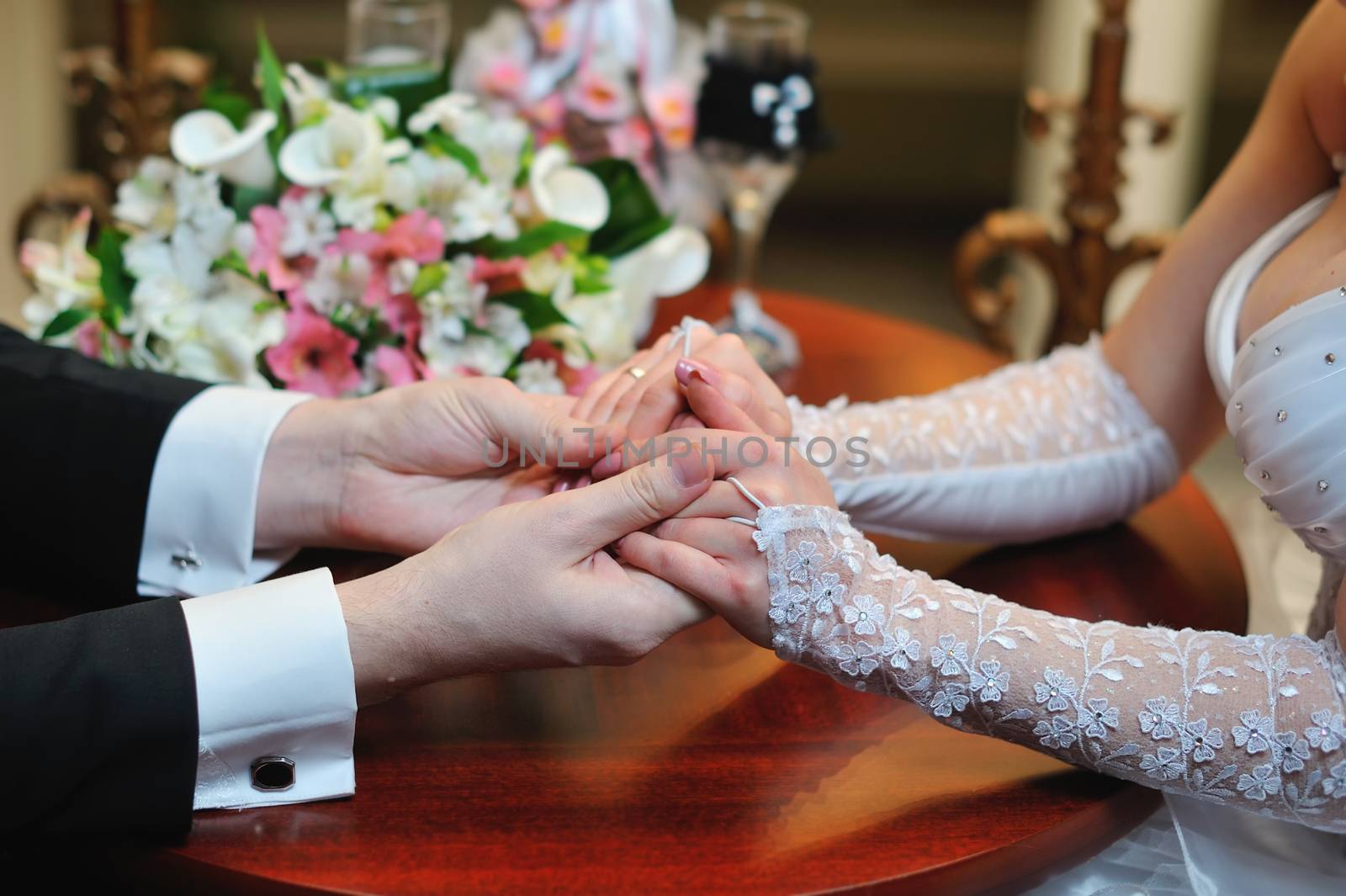 groom holds his bride's hand in appartaments.
