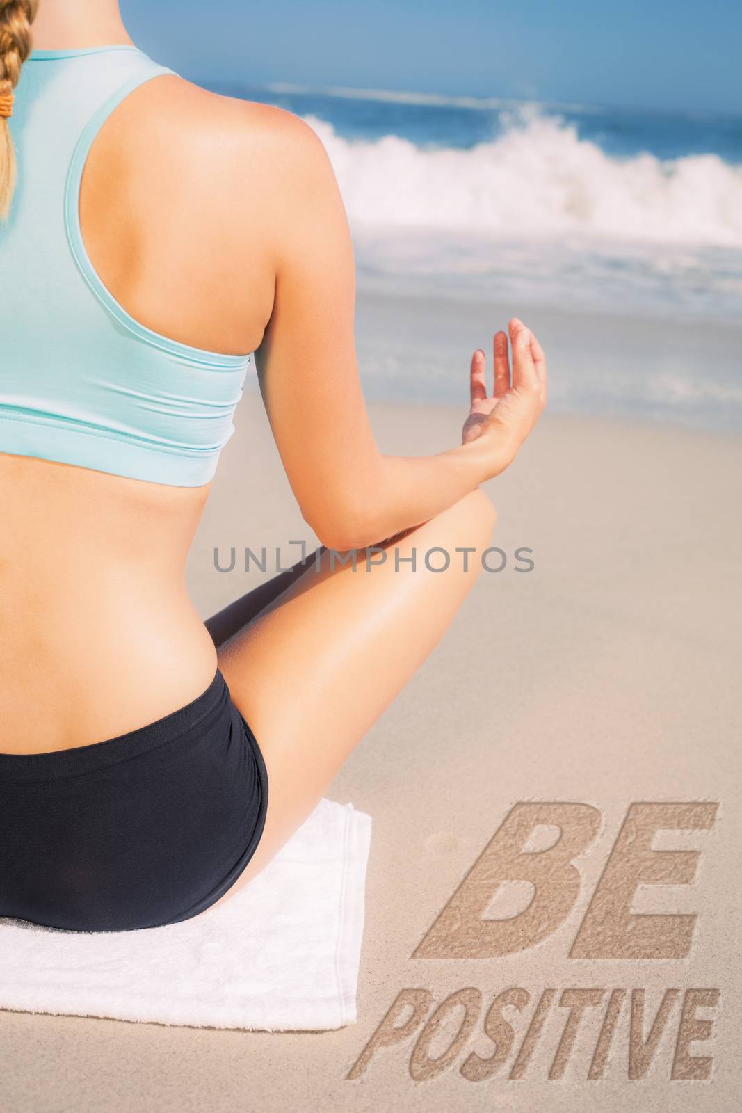 Fit woman sitting on the beach in lotus pose against be positive