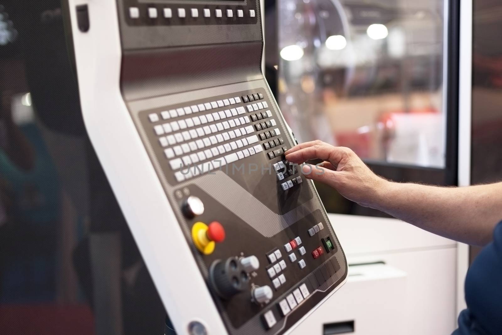 Hand on the control panel of a programmable machine 