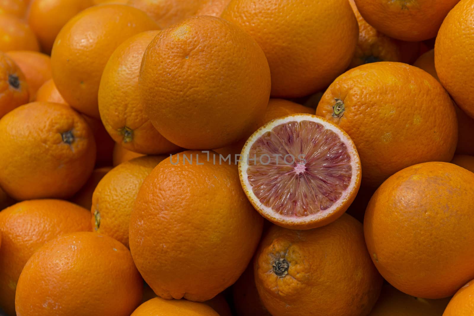 single sliced half blood orange inside oranges.