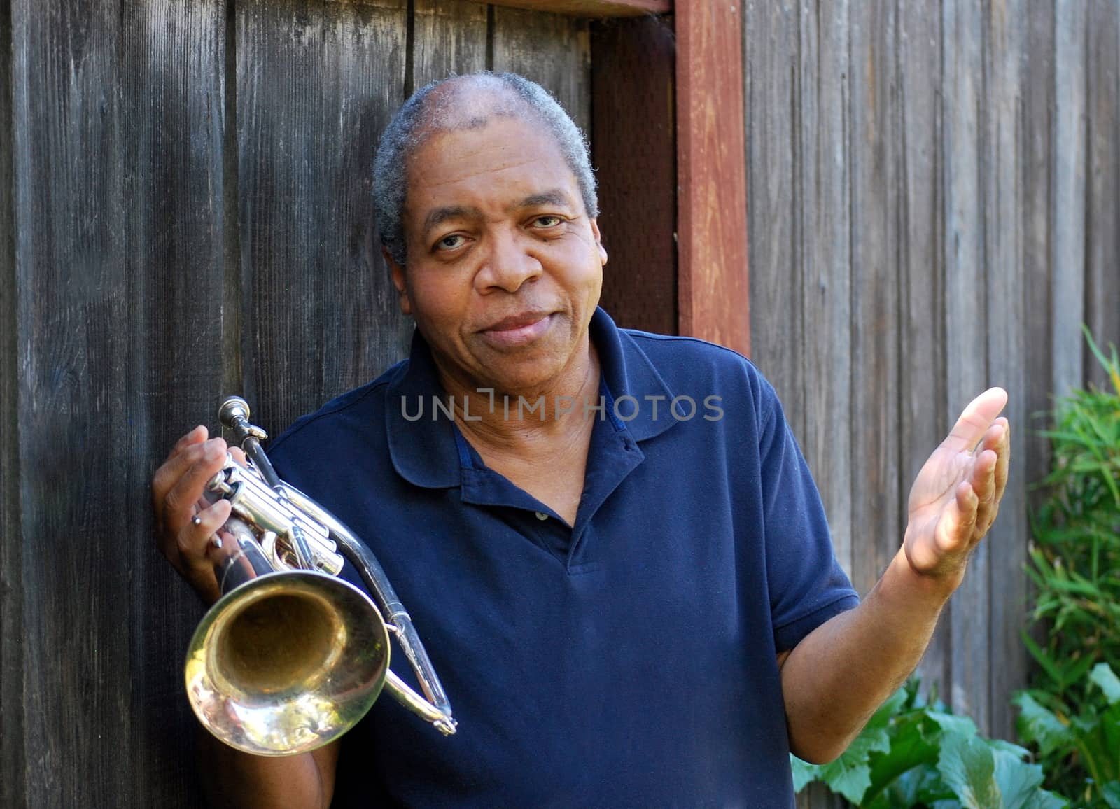 African american jazz musician with his flugelhorn outside.