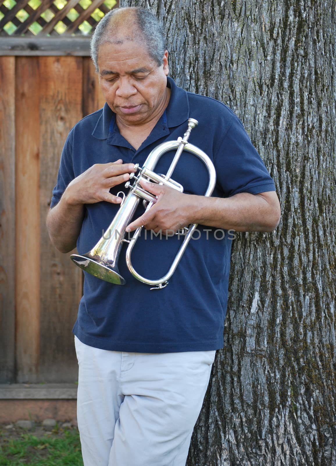 African american jazz musician with his flugelhorn outside.