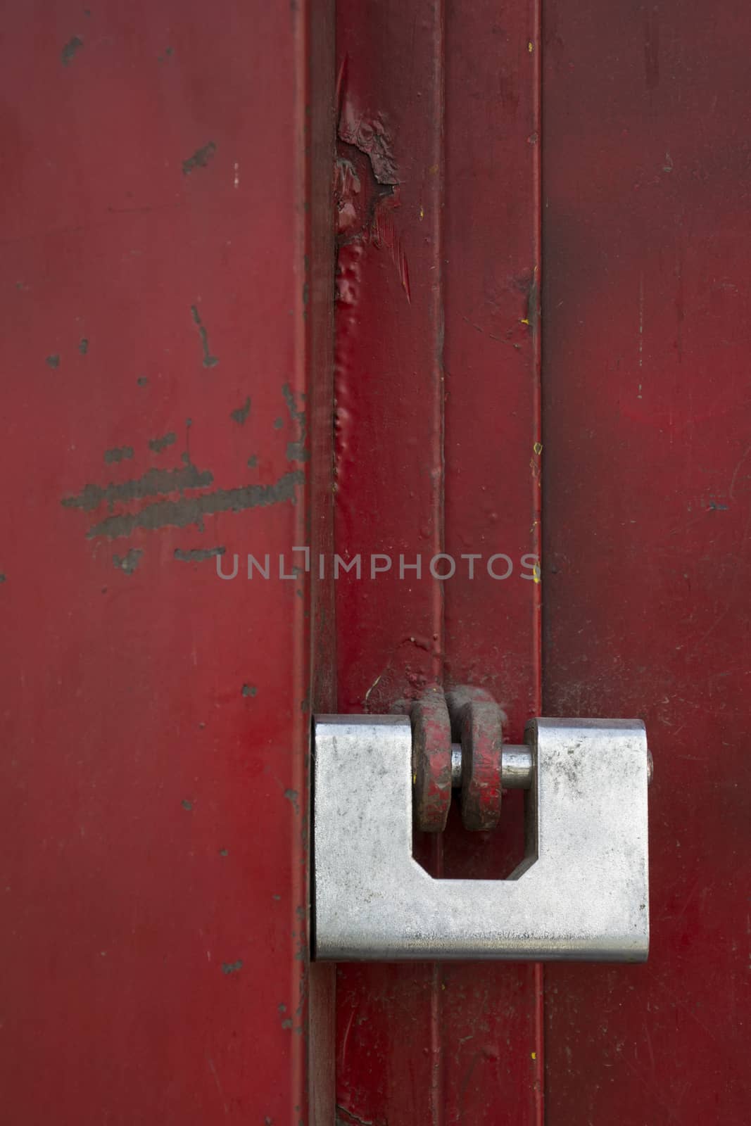 A single lock putted on red door in street.