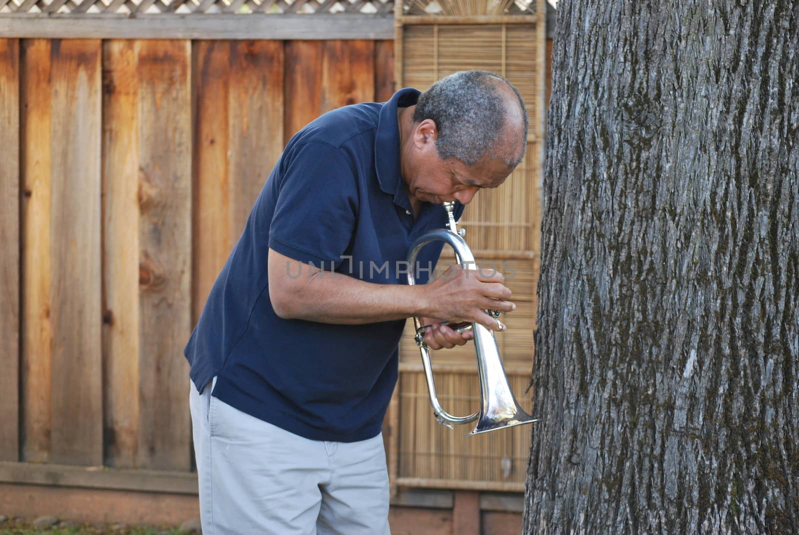 African american jazz musician with his flugelhorn outside.