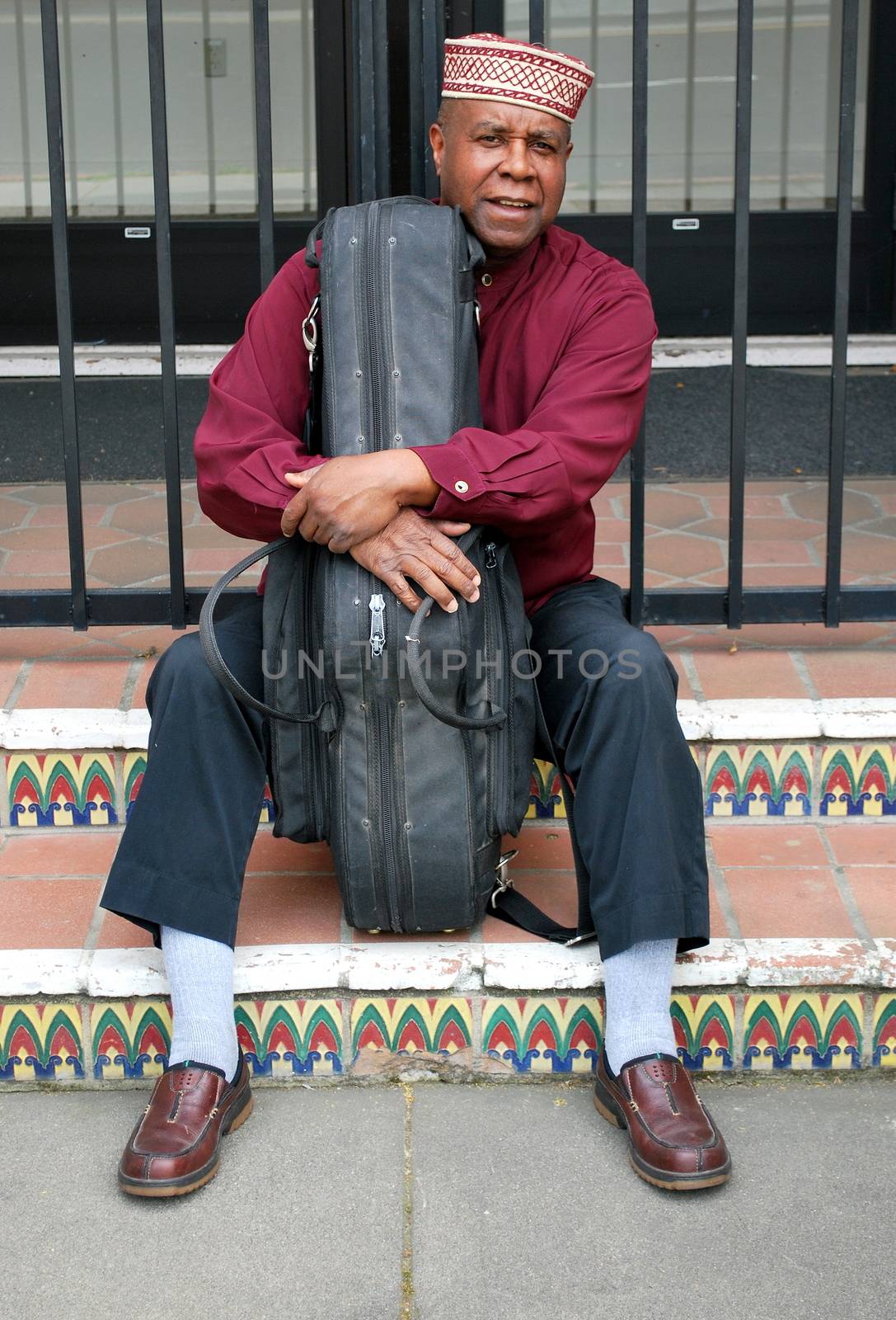 Muslim jazz musician with his saxophone outside.