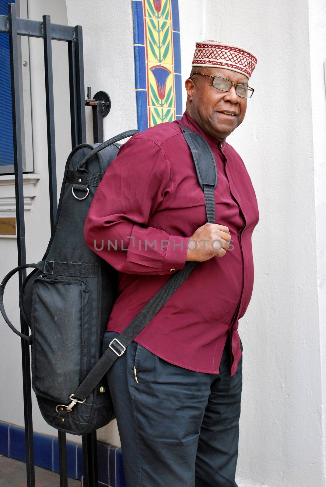 Muslim jazz musician with his saxophone outside.