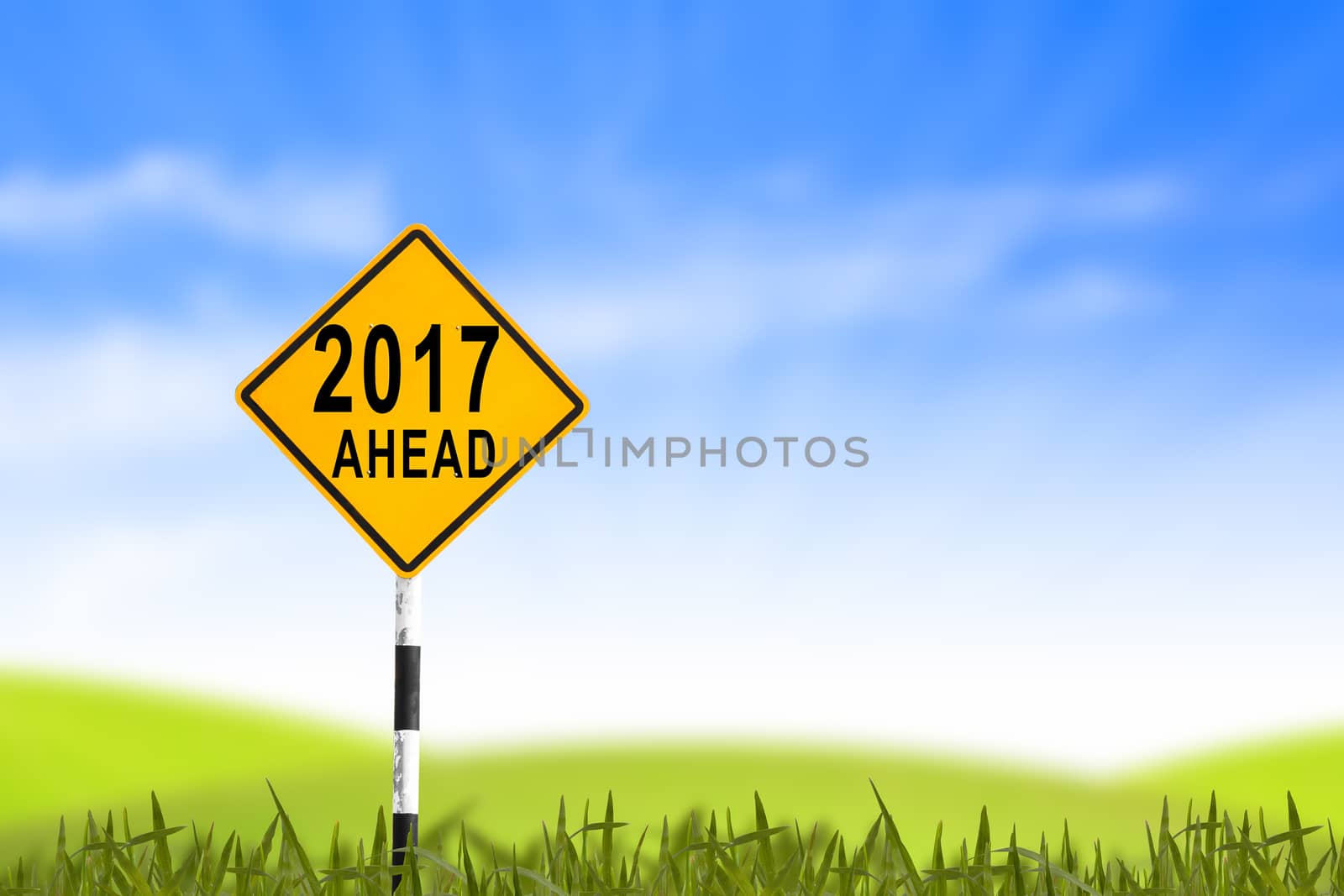 2017, Road sign in the grass field to new year and blue sky, can use as abstract background