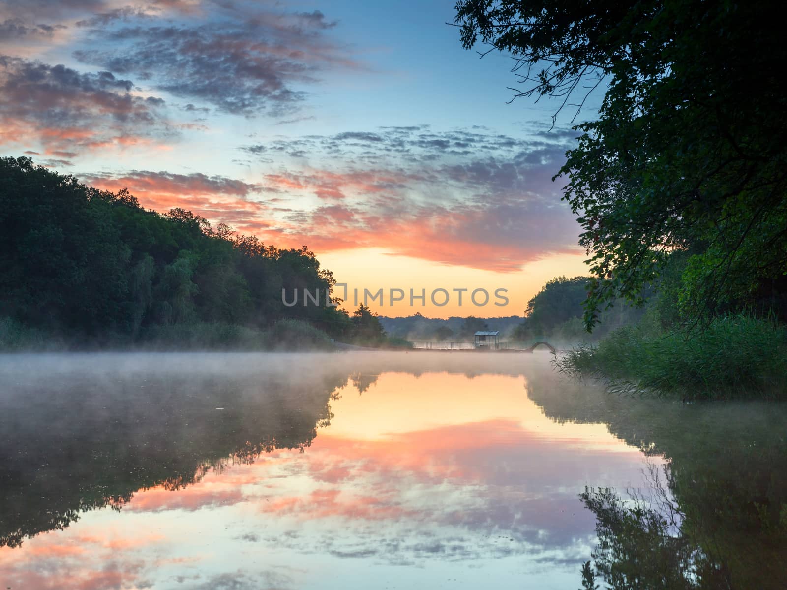 Colourful sunset on the fog river. Ukraine
