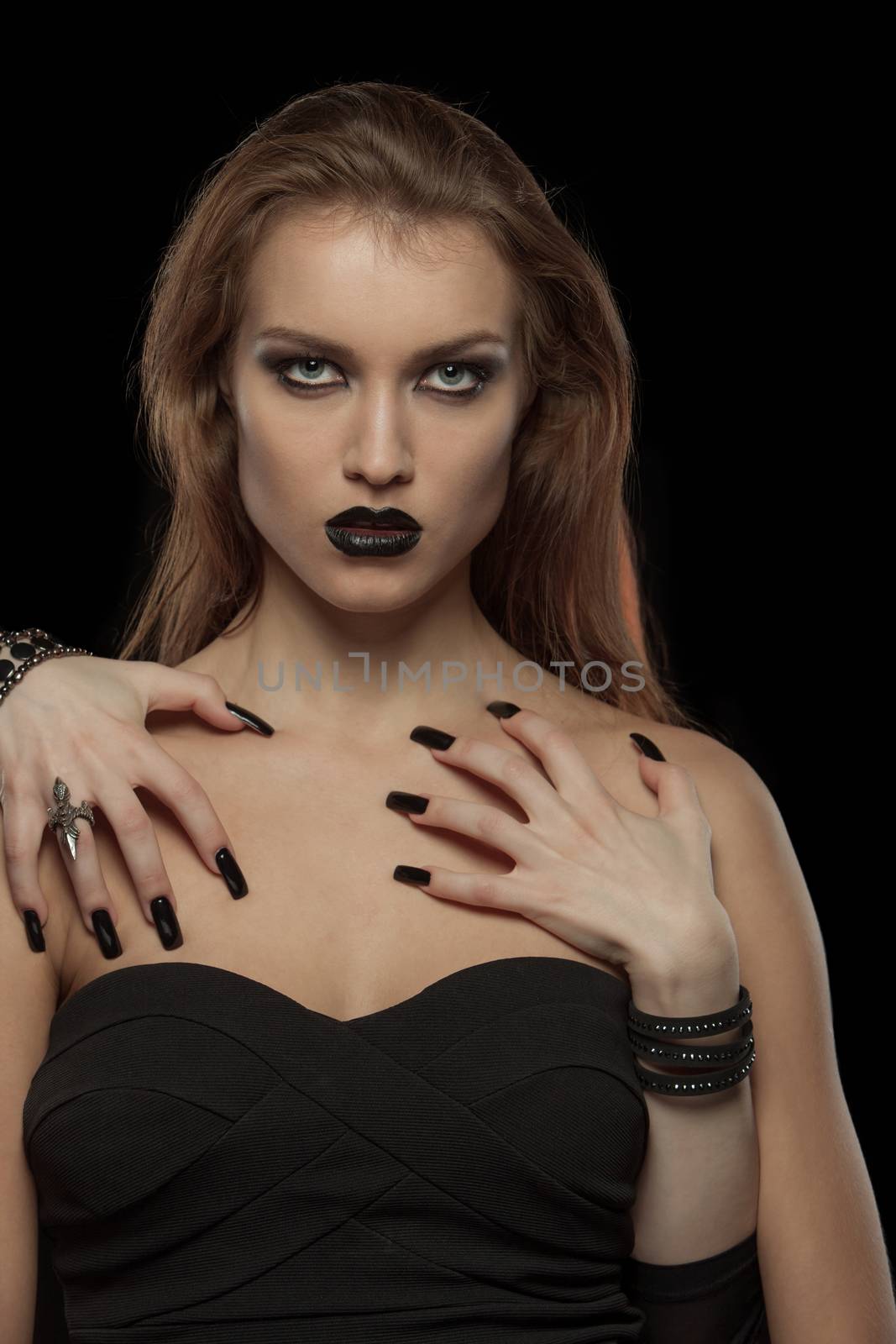 Portrait of a gothic woman with hands of vampire on her body on black background.Halloween