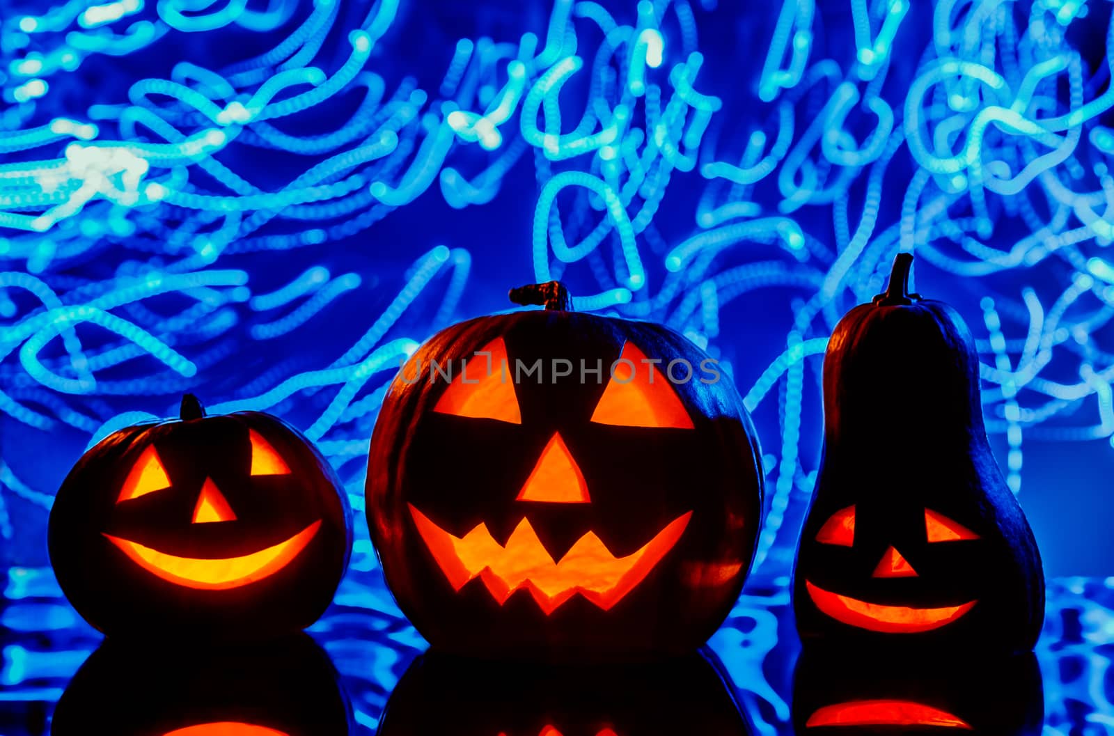 Closeup of scary Halloween pumpkins with lanterns on blue background