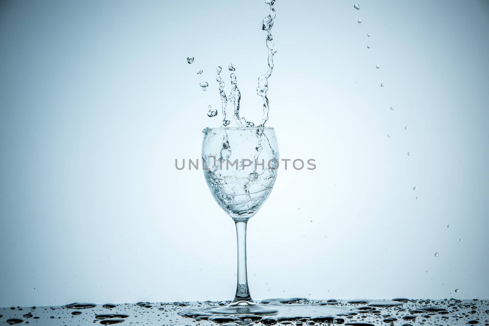 A glass being filled with water on white background