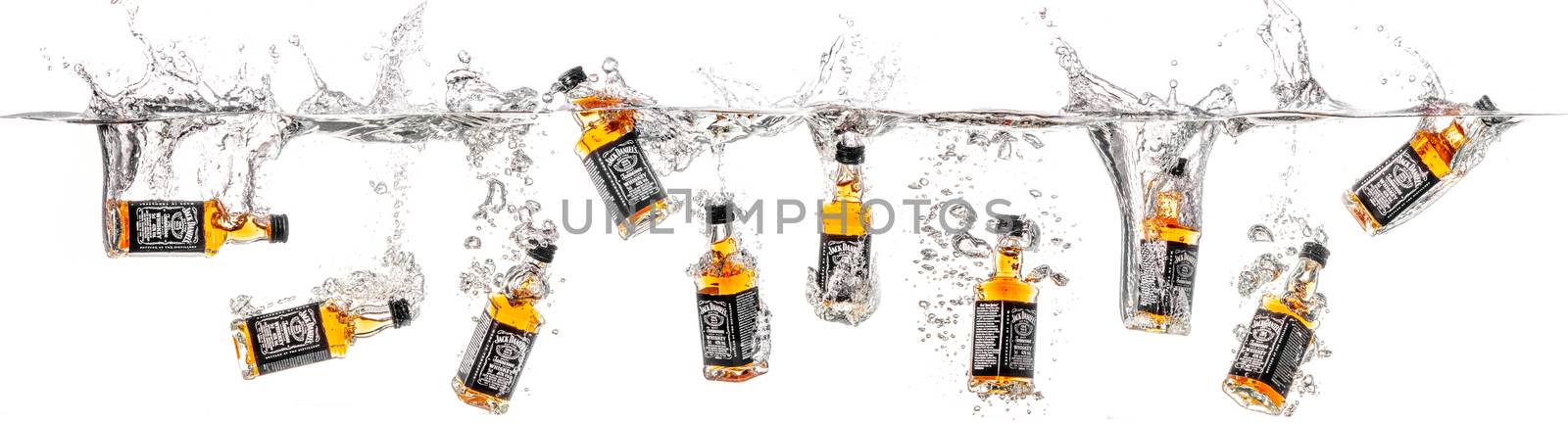 Dnepropetrovsk, Ukraine - January 06, 2015: Bottles of whiskey Jack Daniels falling into water. studio shooting