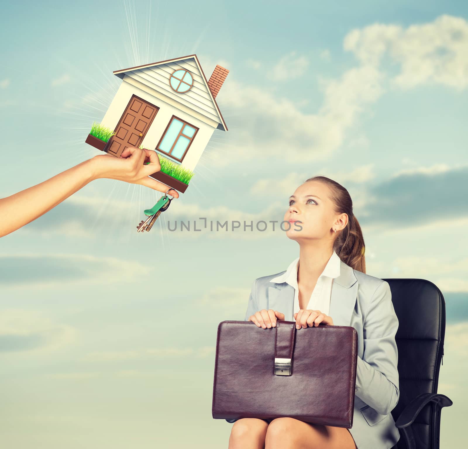 Businesswoman sitting in the chair and looking up at house and keys