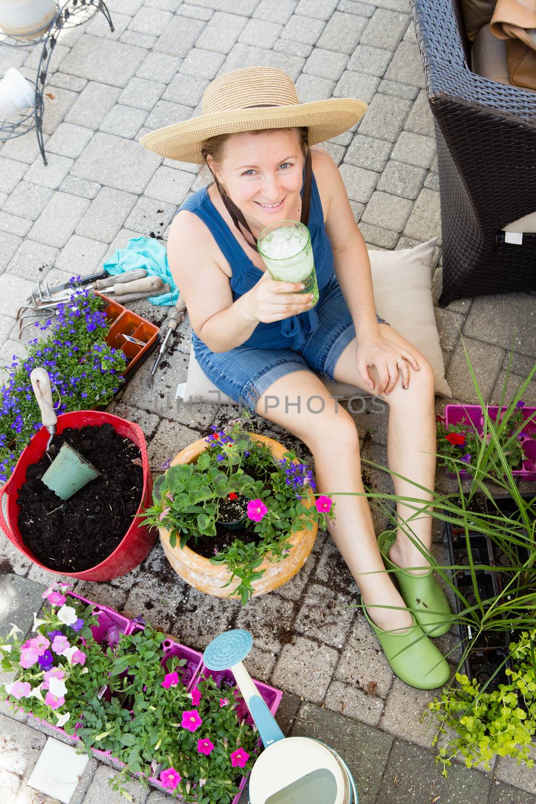 Attractive woman potting up houseplants in spring by coskun