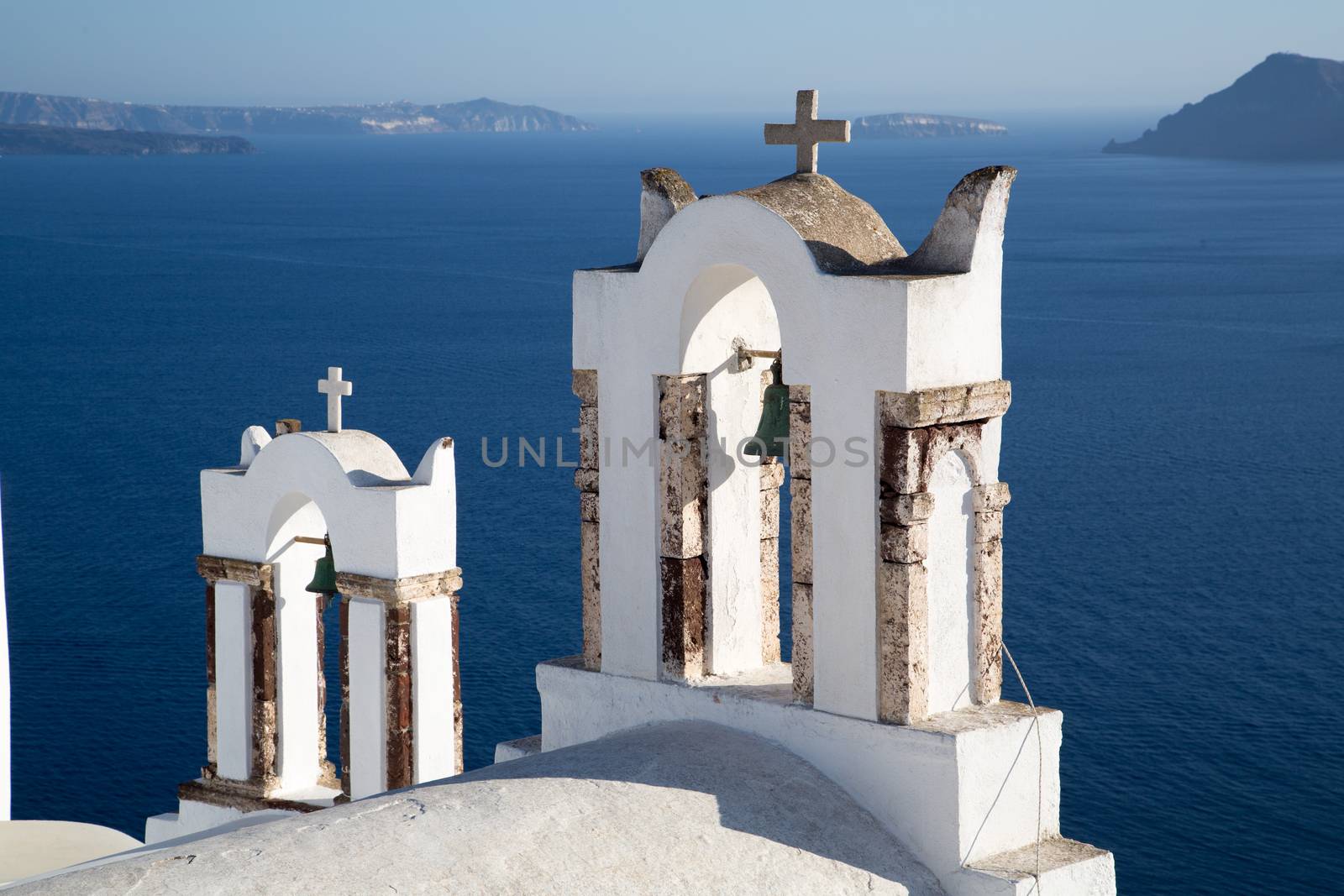 Blue domes and their bell tower in Oia. Santorini