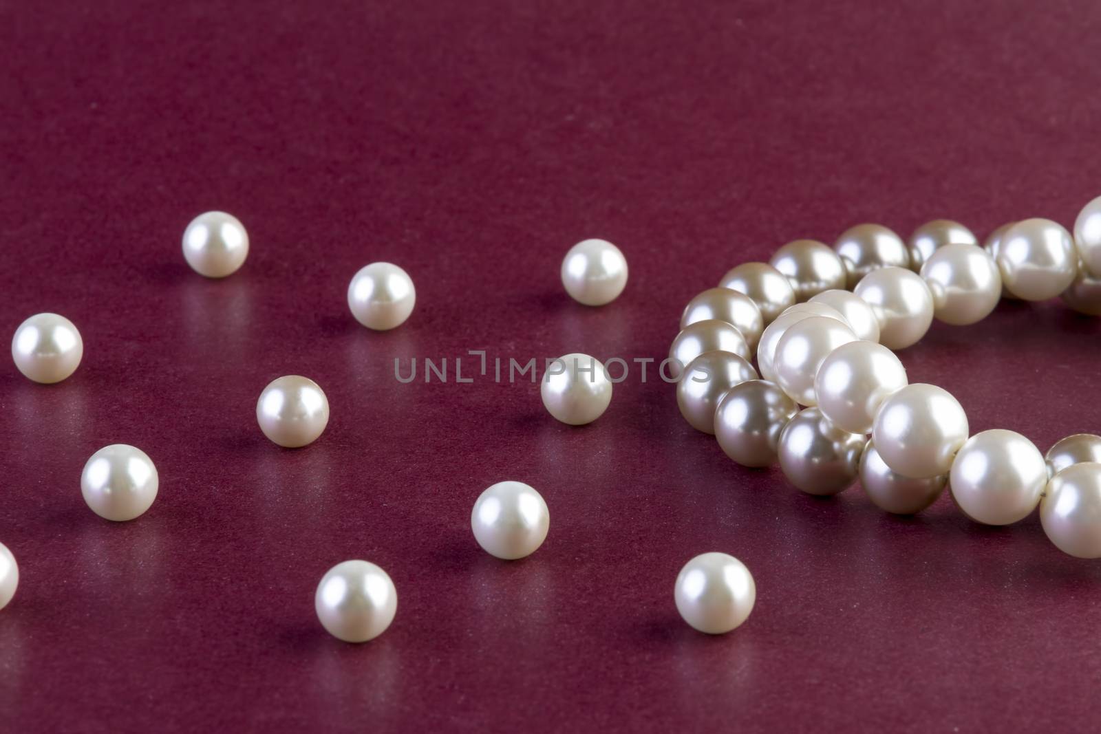 Silver and White pearls necklace on dark red  by manaemedia