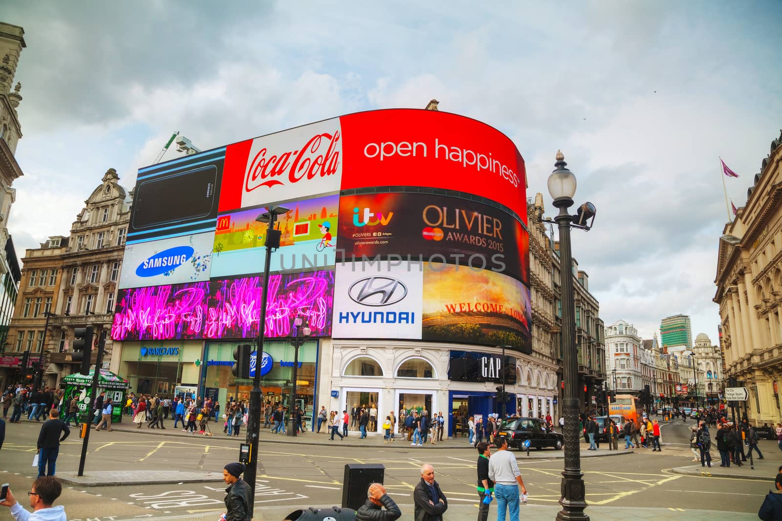 LONDON - APRIL 12: Piccadilly Circus junction crowded by people on April 12, 2015 in London, UK. It's a road junction and public space of London's West End in the City of Westminster, built in 1819.