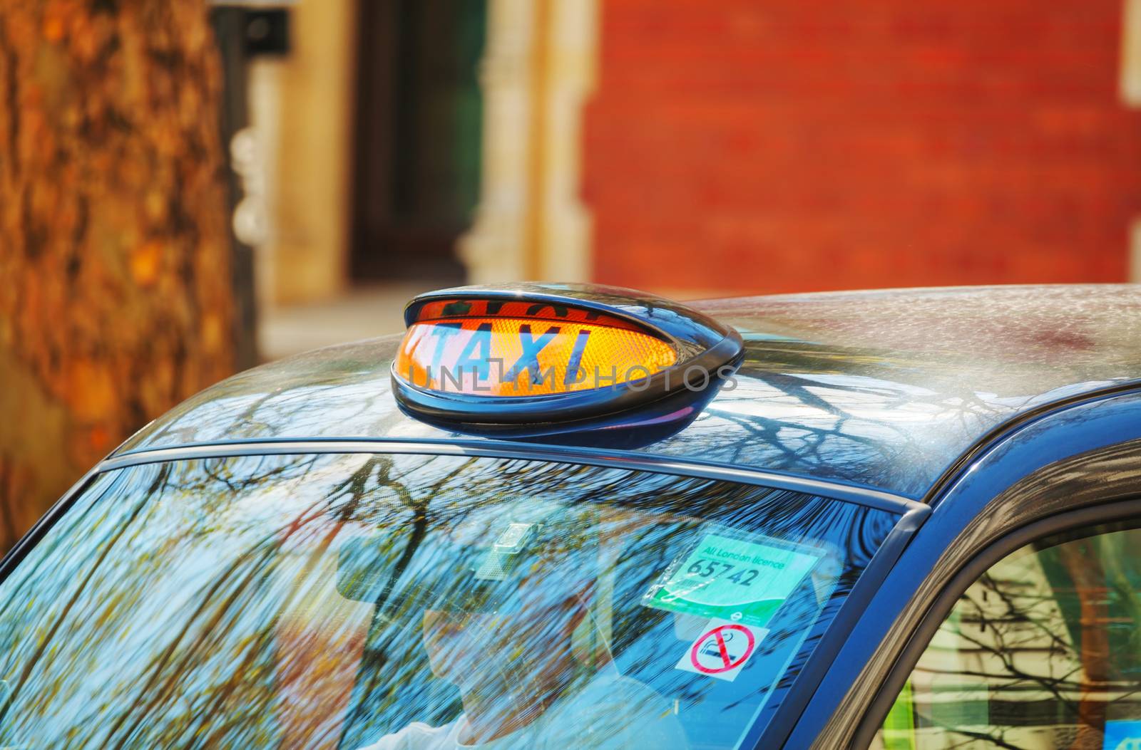 LONDON - APRIL 12: Famous taxi cab (hackney) an a street on April 12, 2015 in London, UK. A hackney or hackney carriage (also called a cab, black cab, hack or London taxi) is a carriage or automobile for hire.