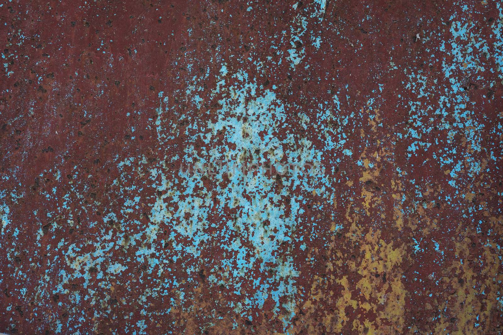 Rusty and weathered color paint on an old door.