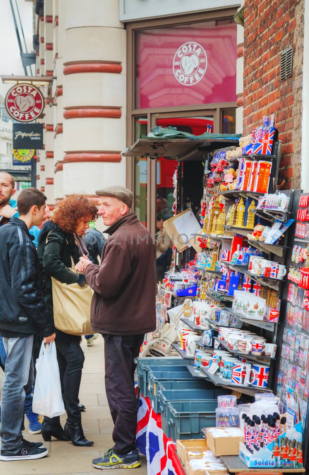 LONDON - APRIL 13: Street souvenir shop with tourists on April 13, 2015 in London, UK. London is a popular centre for tourism, one of its prime industries, employing the equivalent of 350,000 full-time workers.
