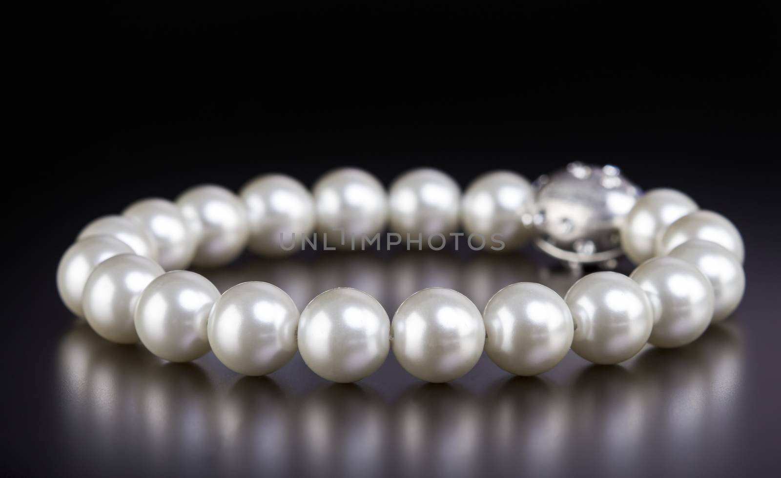 White pearls necklace on black background