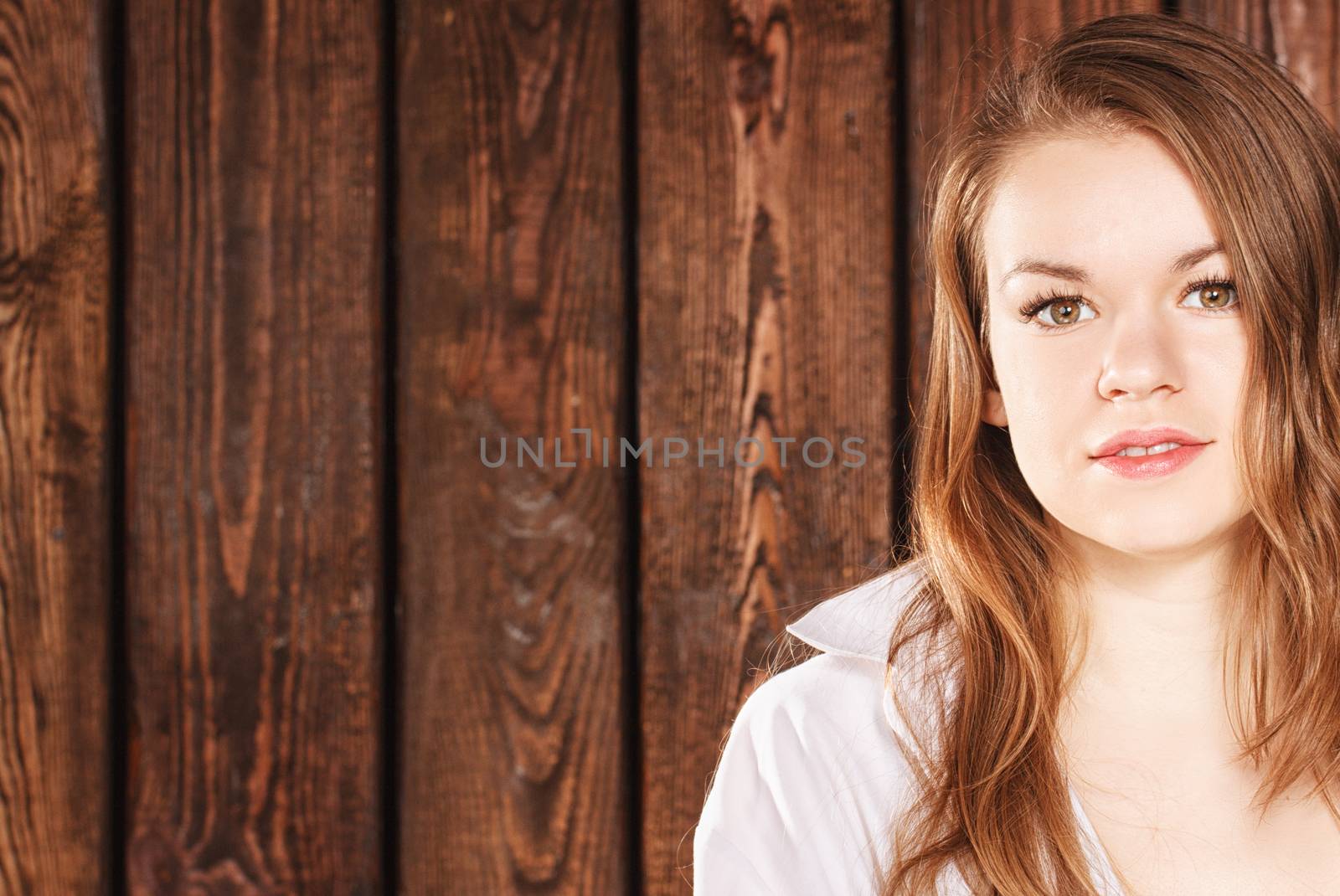 Portrait of a girl on a background of a wooden wall