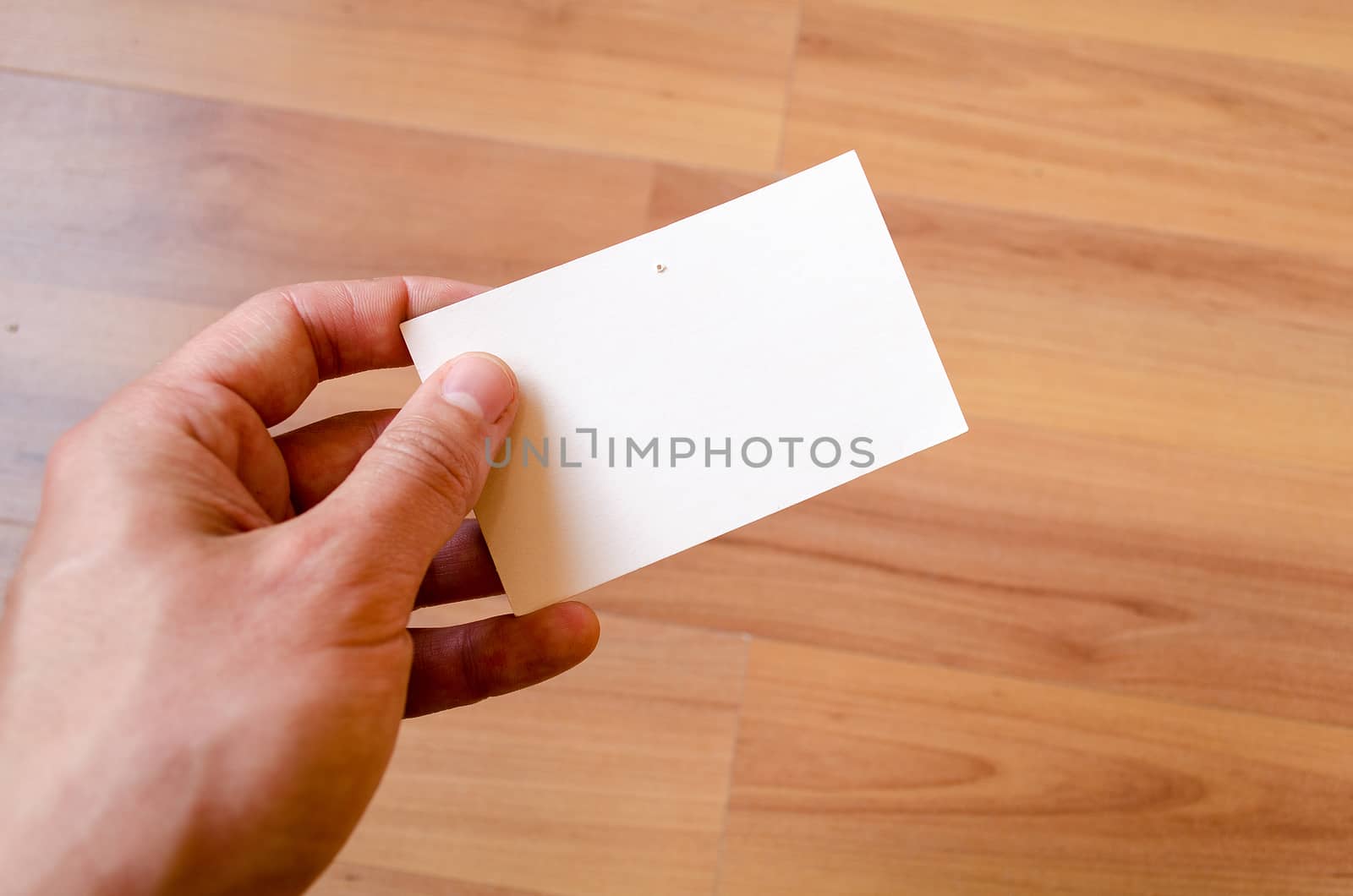 Man hand hold note with wood table office background