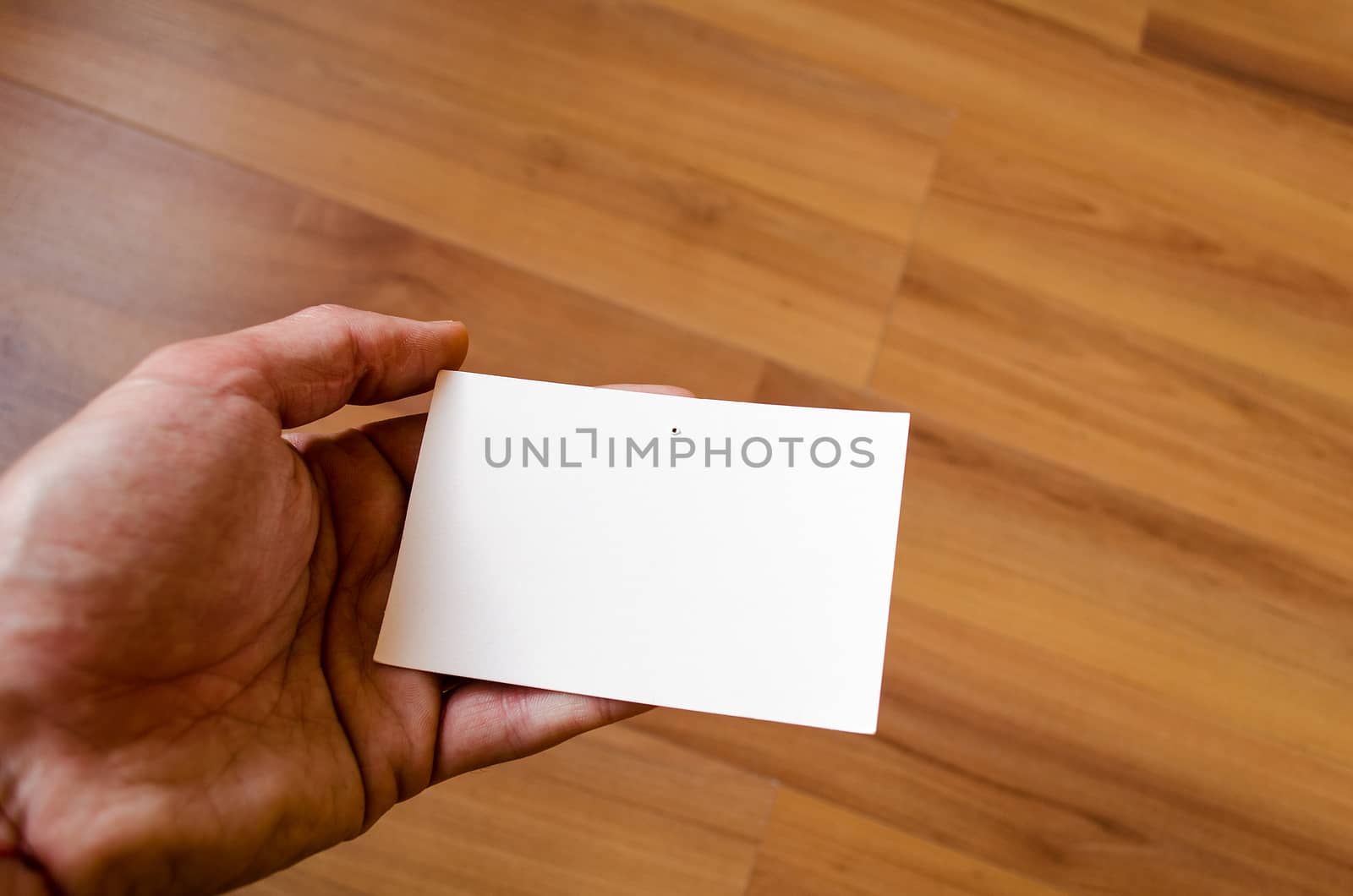 Man hand hold note with wood table office background