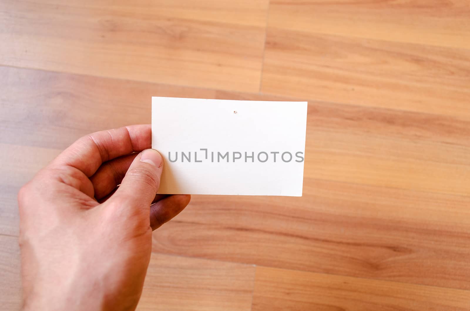 Man hand hold note with wood table office background