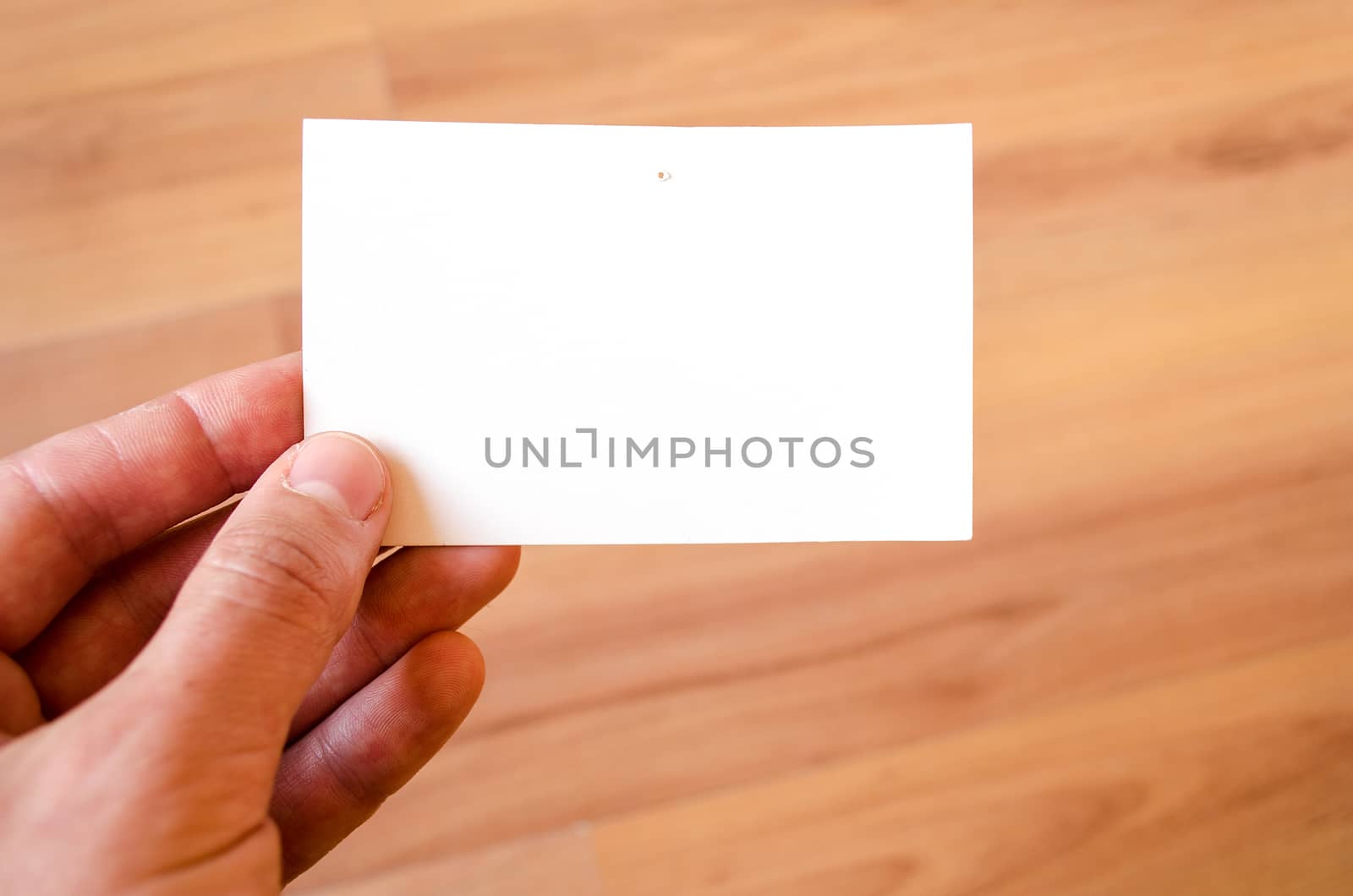 Man hand hold note with wood table office background