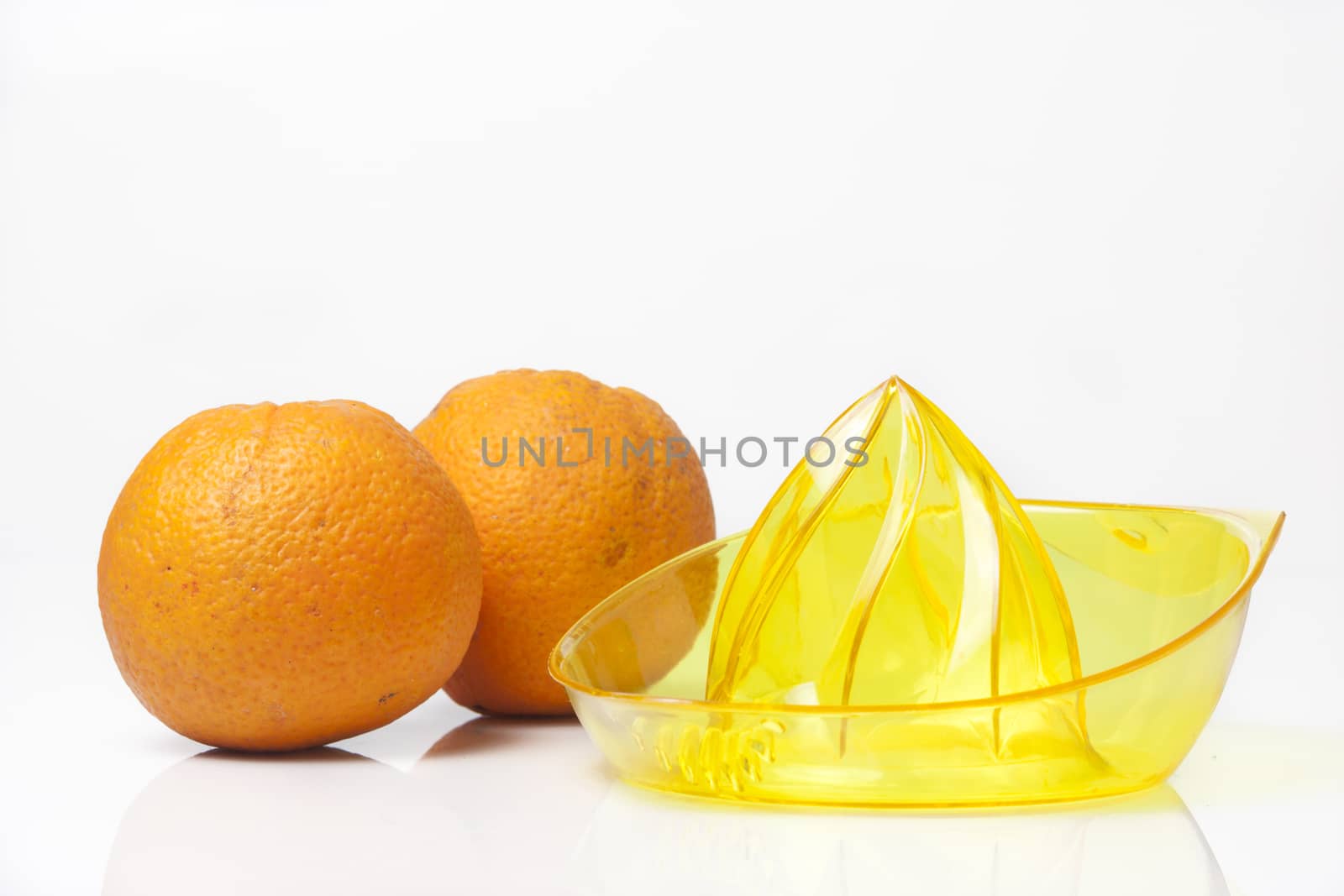 Fresh made orange juice set with oranges and juicer.
High key and soft shadows