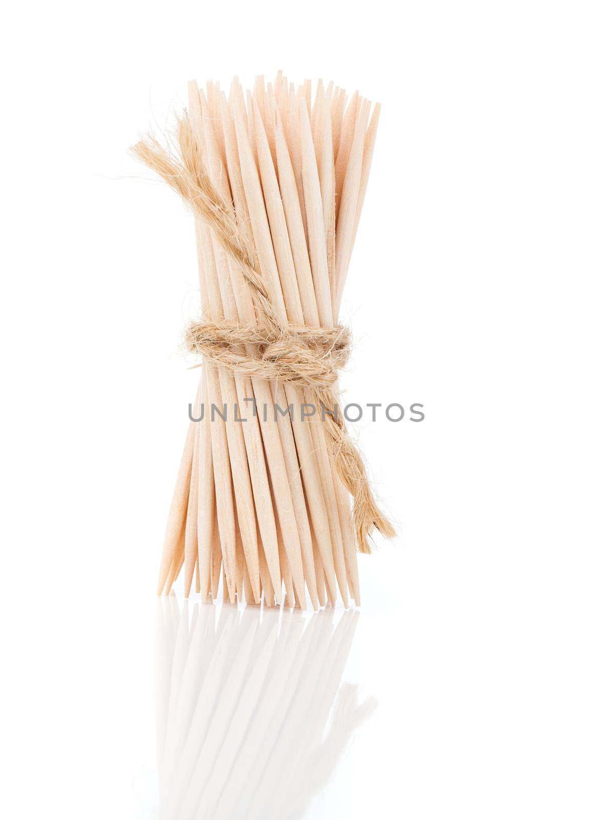 Bunch of brown toothpicks on white background by motorolka