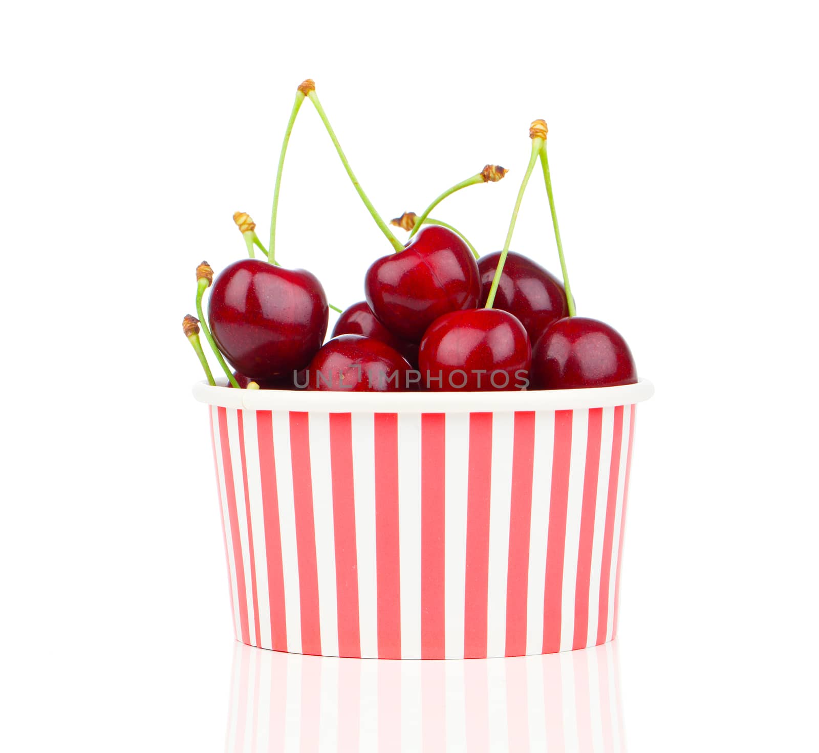 fresh cherry berries in striped bucket on white background