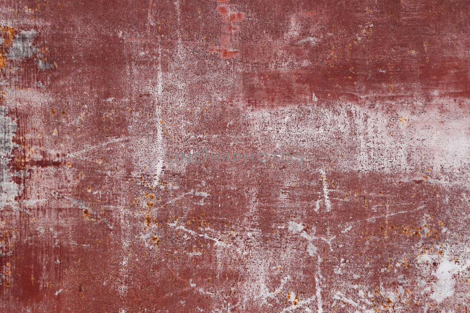 red scratched metal surface with peeling paint