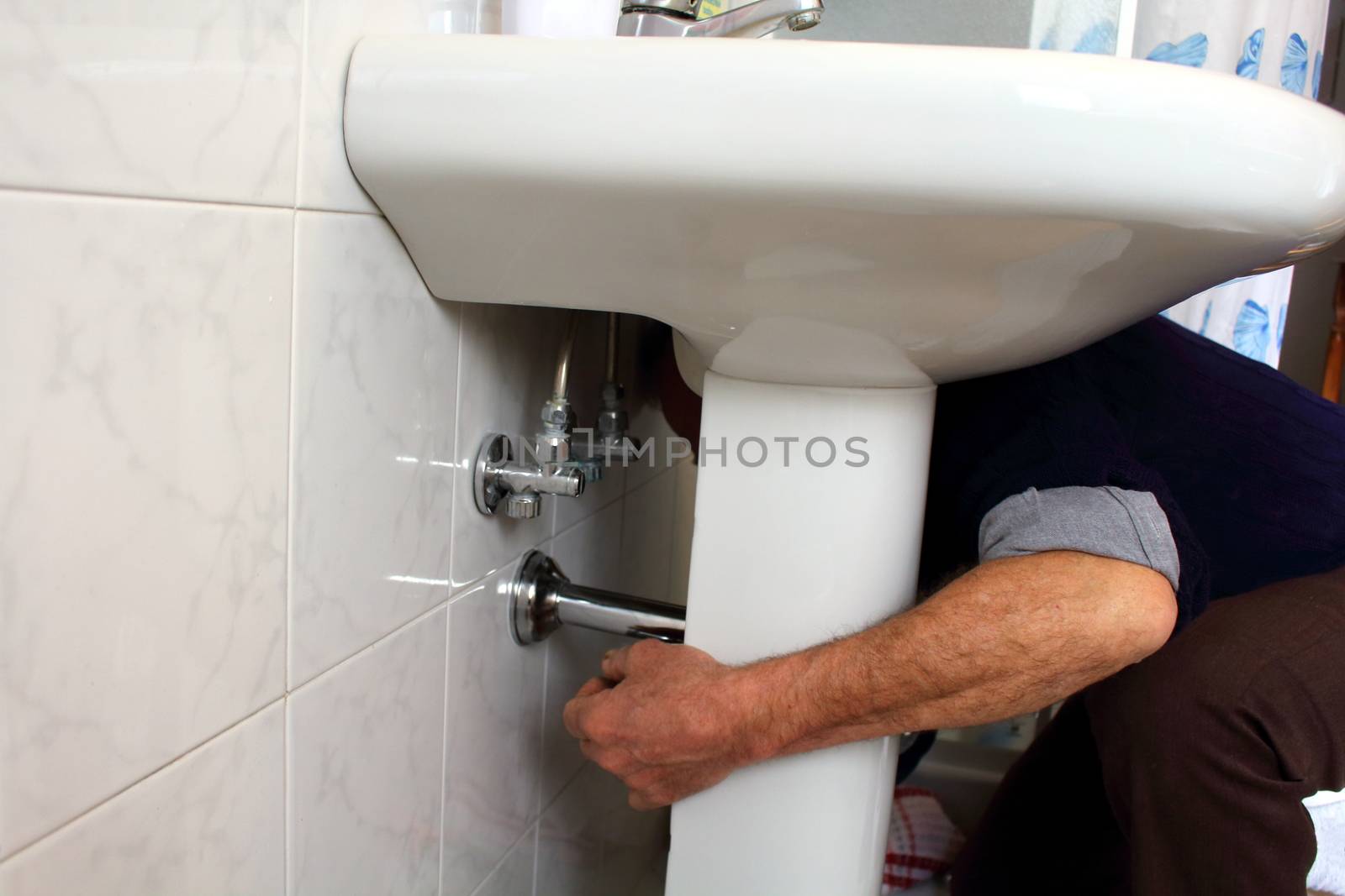 plumber fixing a drain of the sink