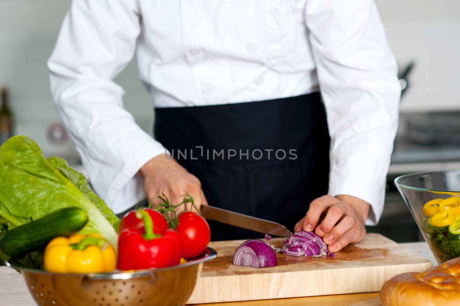 Chef chopping vegetables on a wooden cutting board