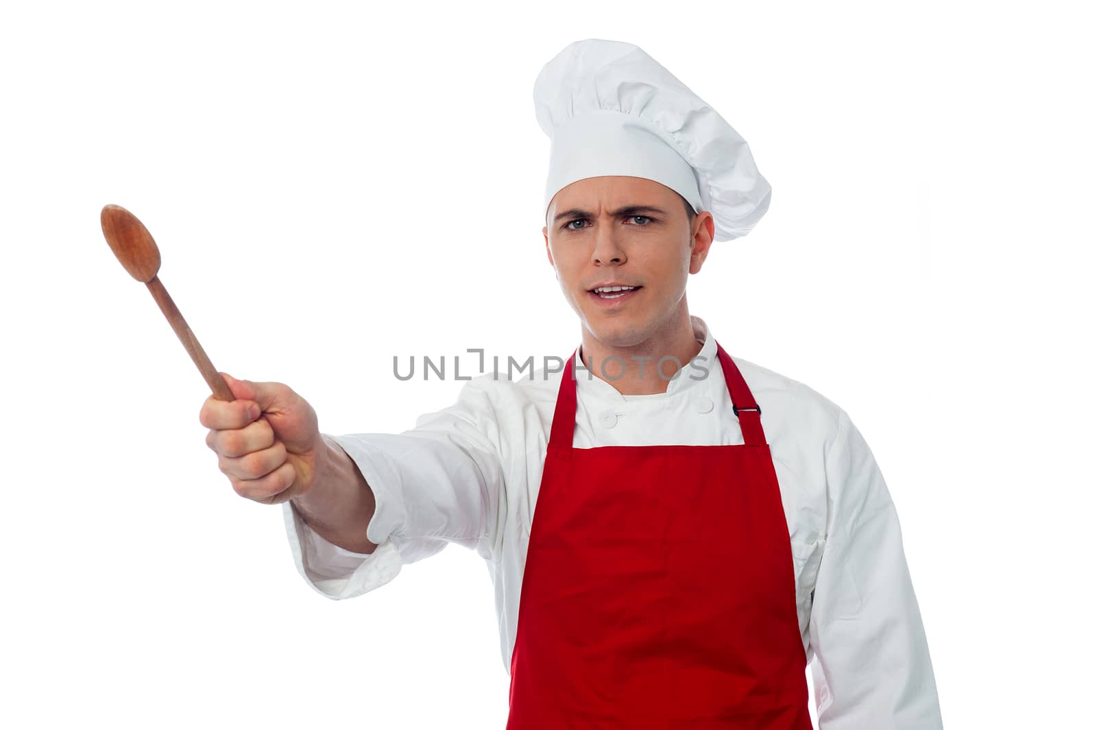 Portrait of young male chef holding utensil on white background