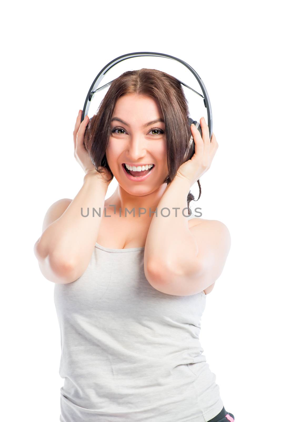 brunette with headphones listening to music on a white background