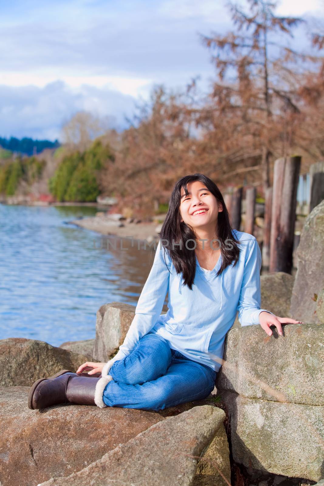 Happy young teen girl face upturned, smiling, while sitting outd by jarenwicklund
