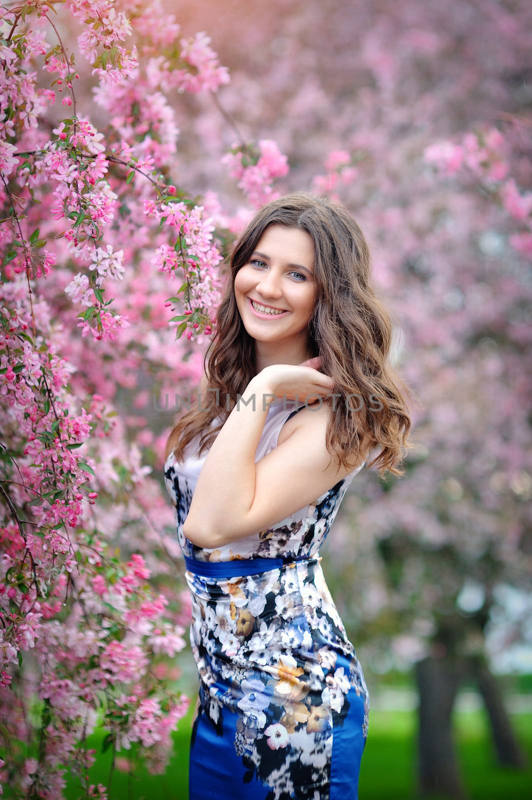 portrait of a beautiful brunette girl in the flowered spring garden.