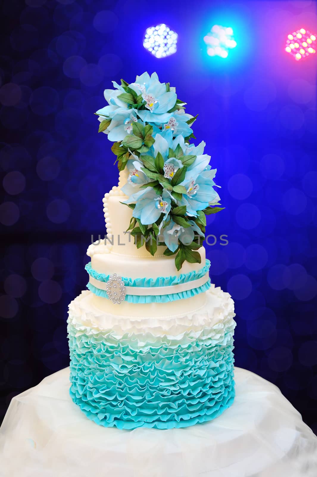 beautiful turquoise three-tiered wedding cake on table.