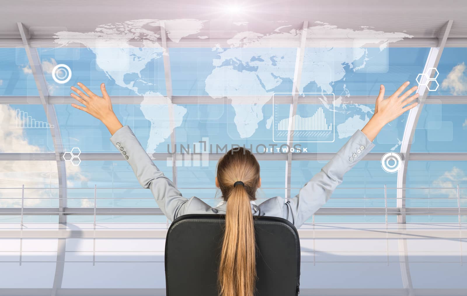 Rear view of businesswoman sitting in chair with arms up in front of window with virtual world map