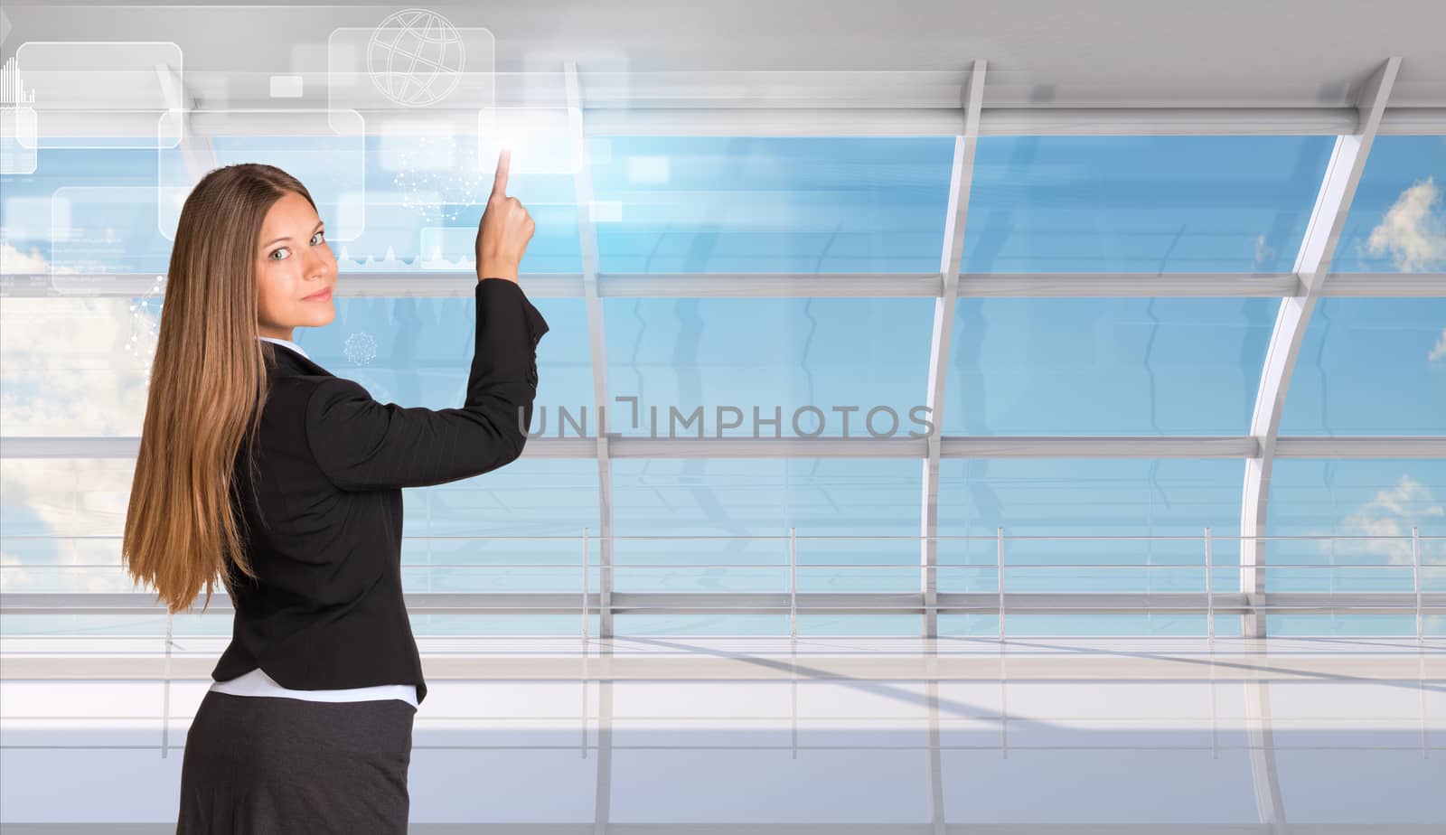 Businesswoman standing back and looking at the camera pressing on holographic screen with graphical charts