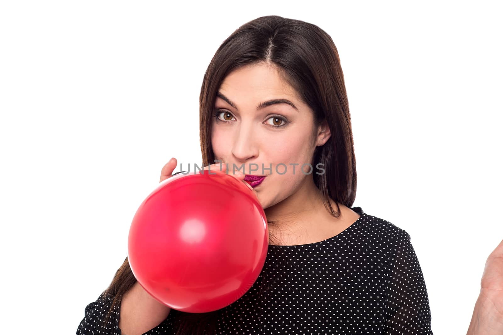 Attractive woman blowing a red balloon 