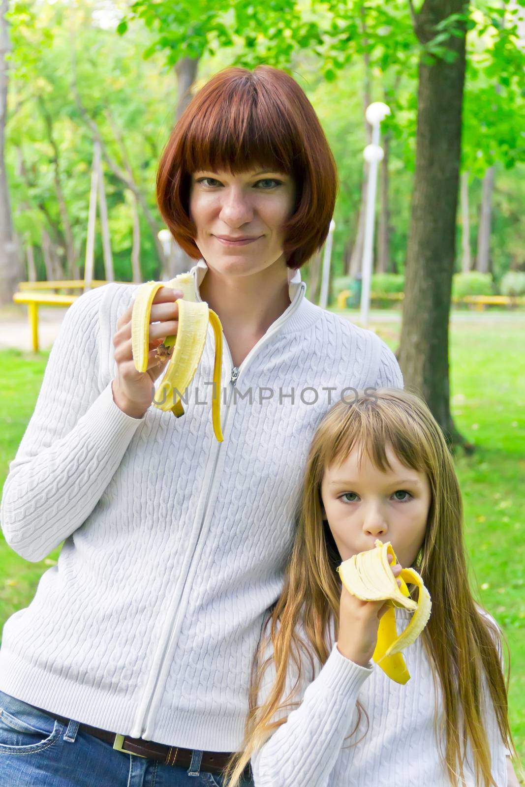 Photo of mother and daughter eating banana