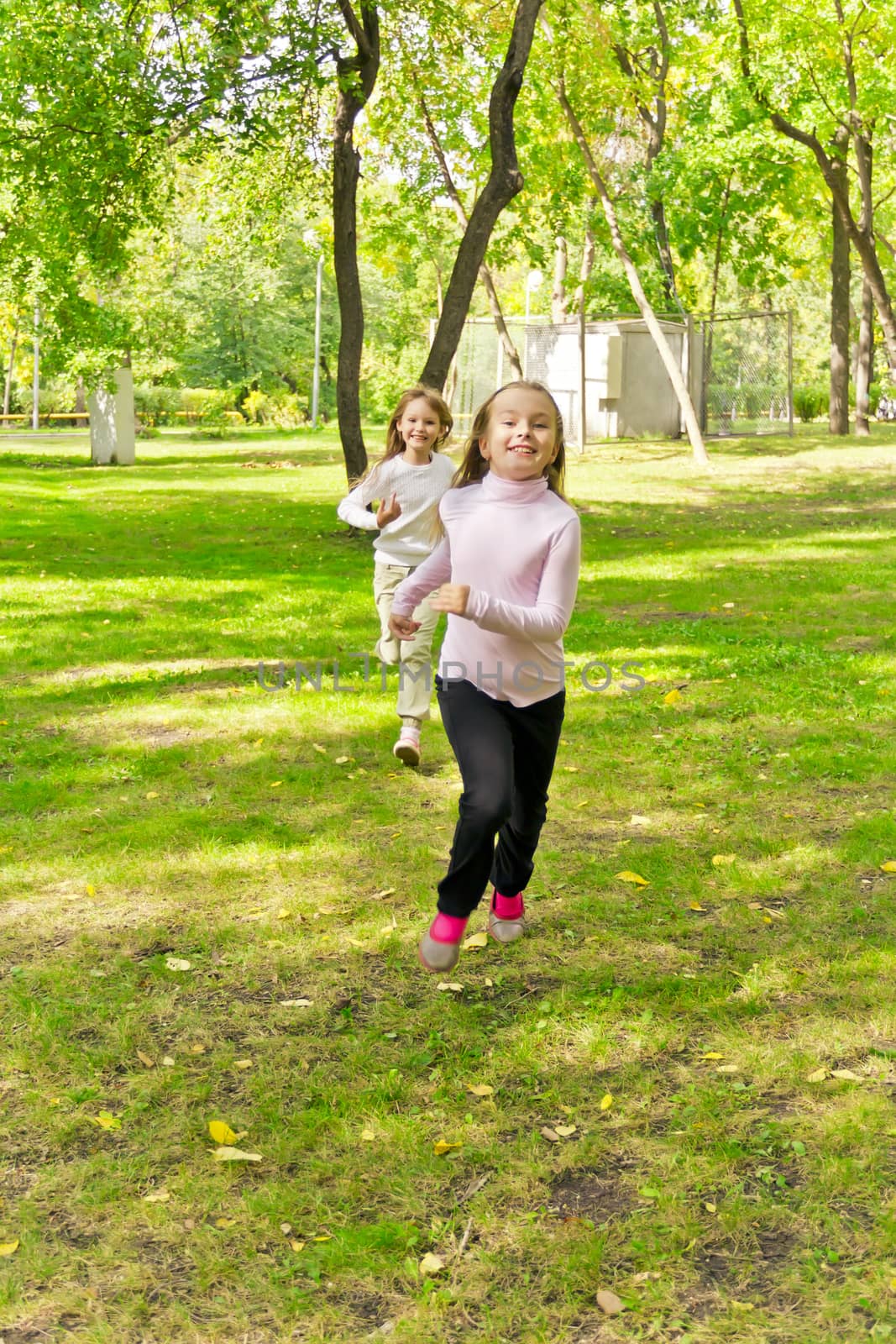 Photo of two running girls in summer