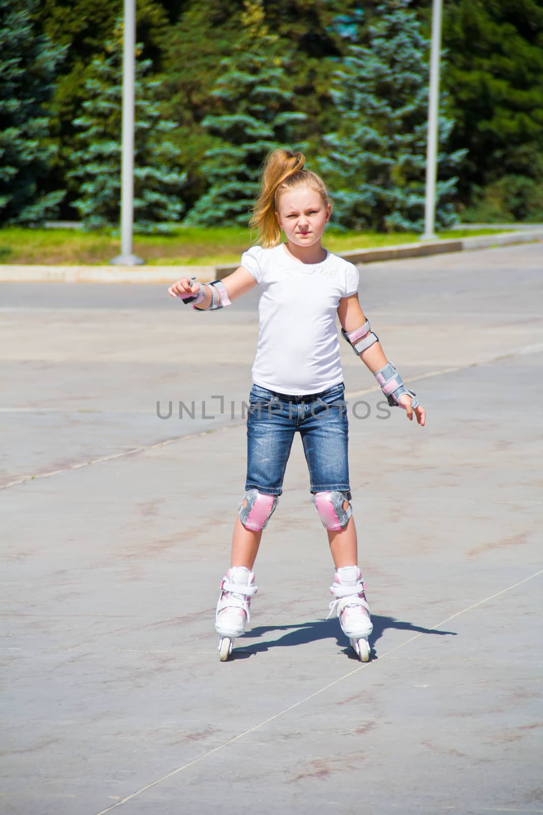 Photo of cute girl on roller skates in summer