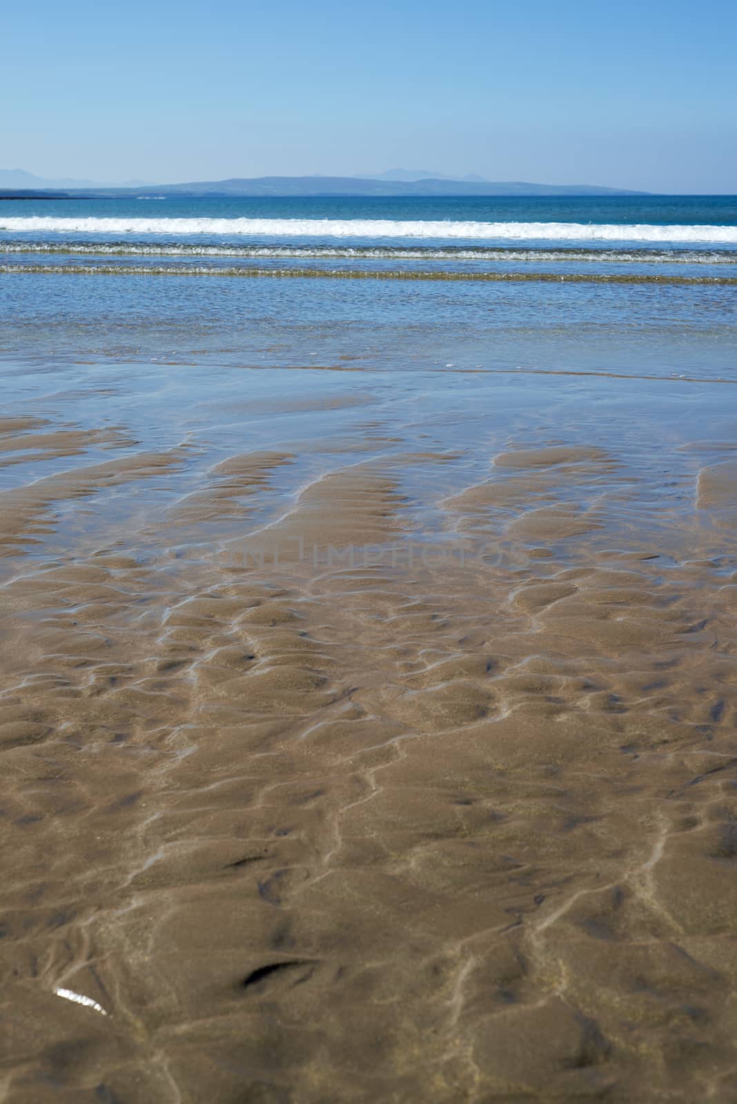 calm soft waves lashing onto ballybunion beach by morrbyte