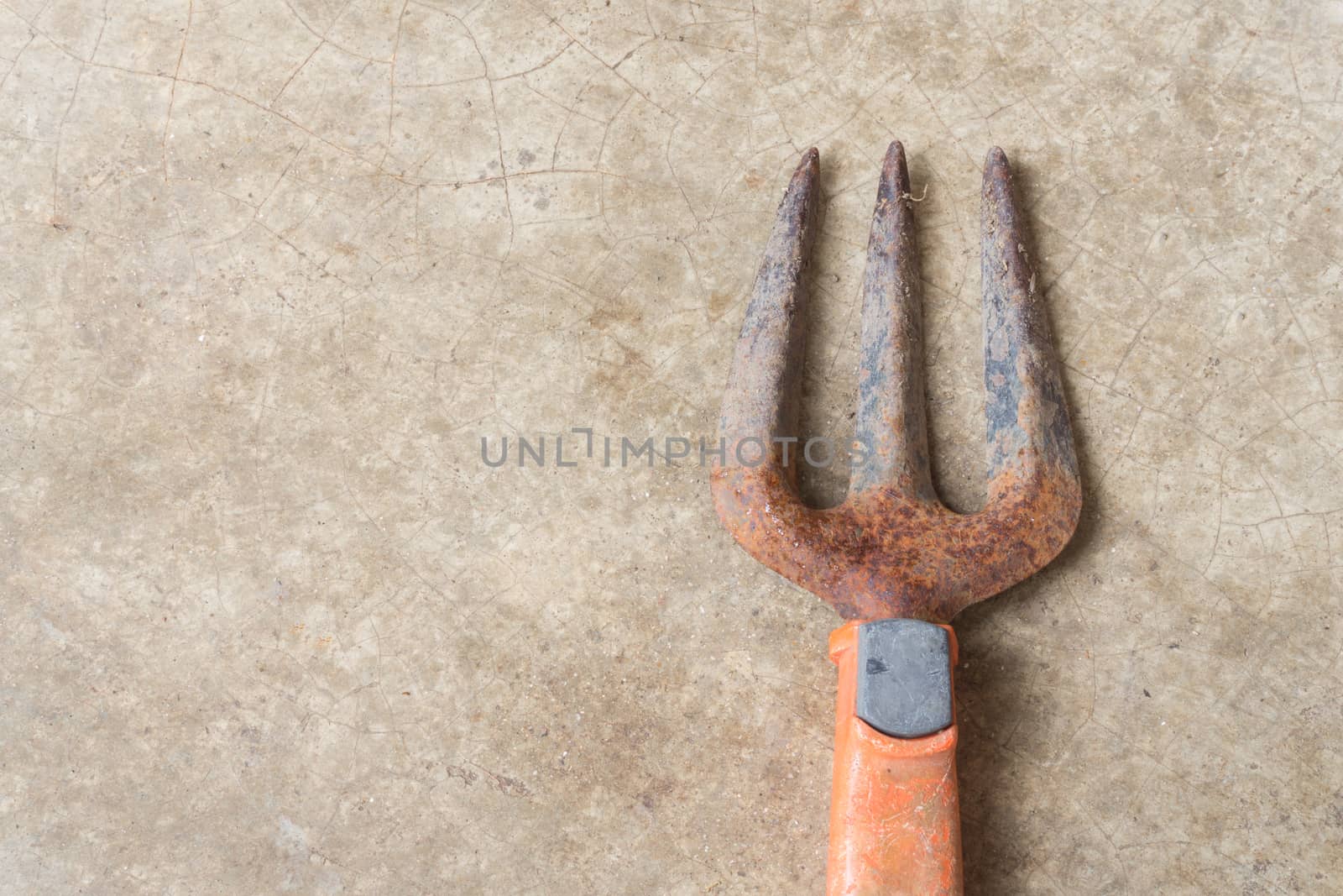 Rusty Old Fork Gardening Tool on Concrete Floor Background