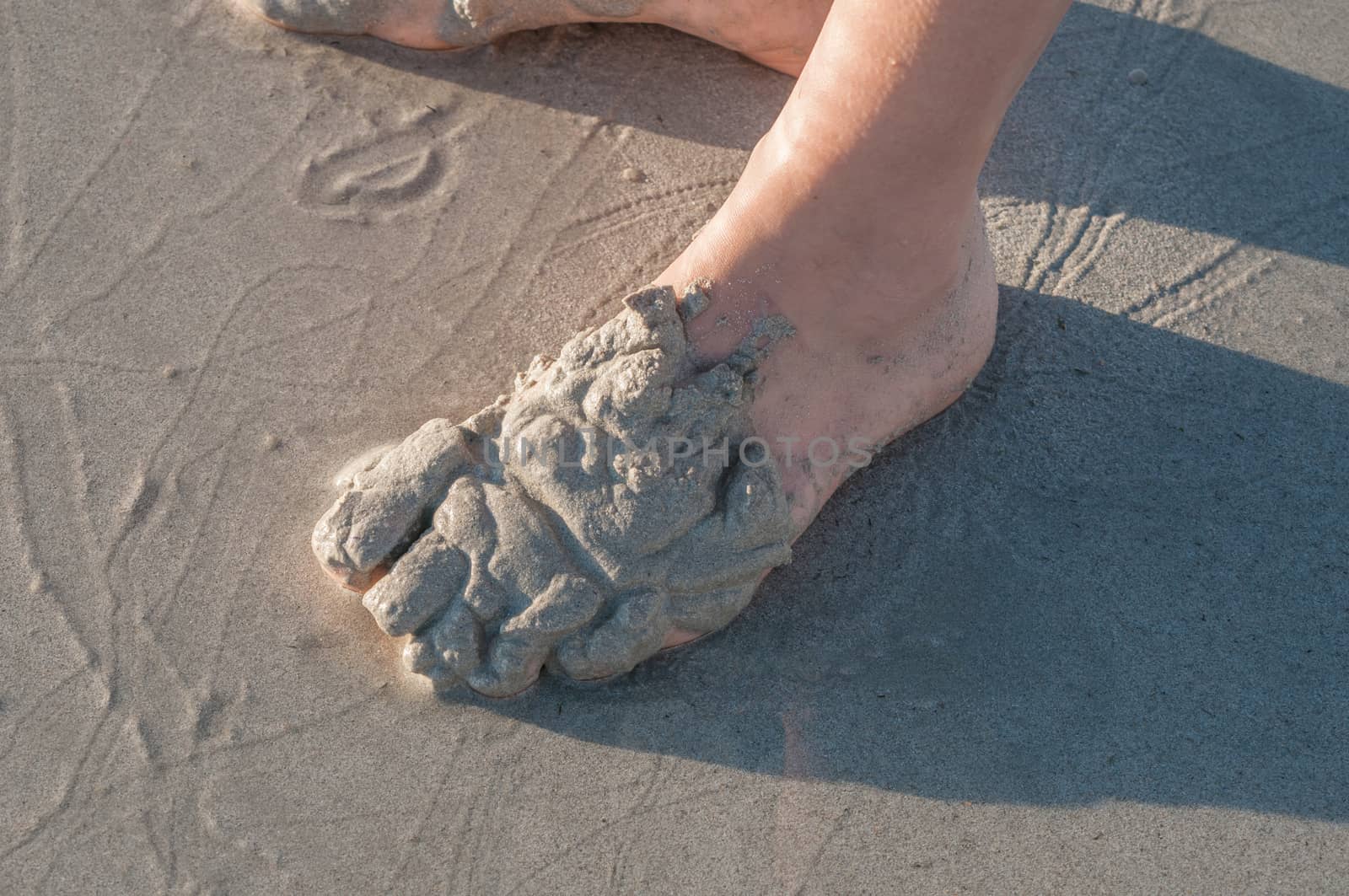 Person playing in the sand on a beach in The Strand, South Africa at sunset